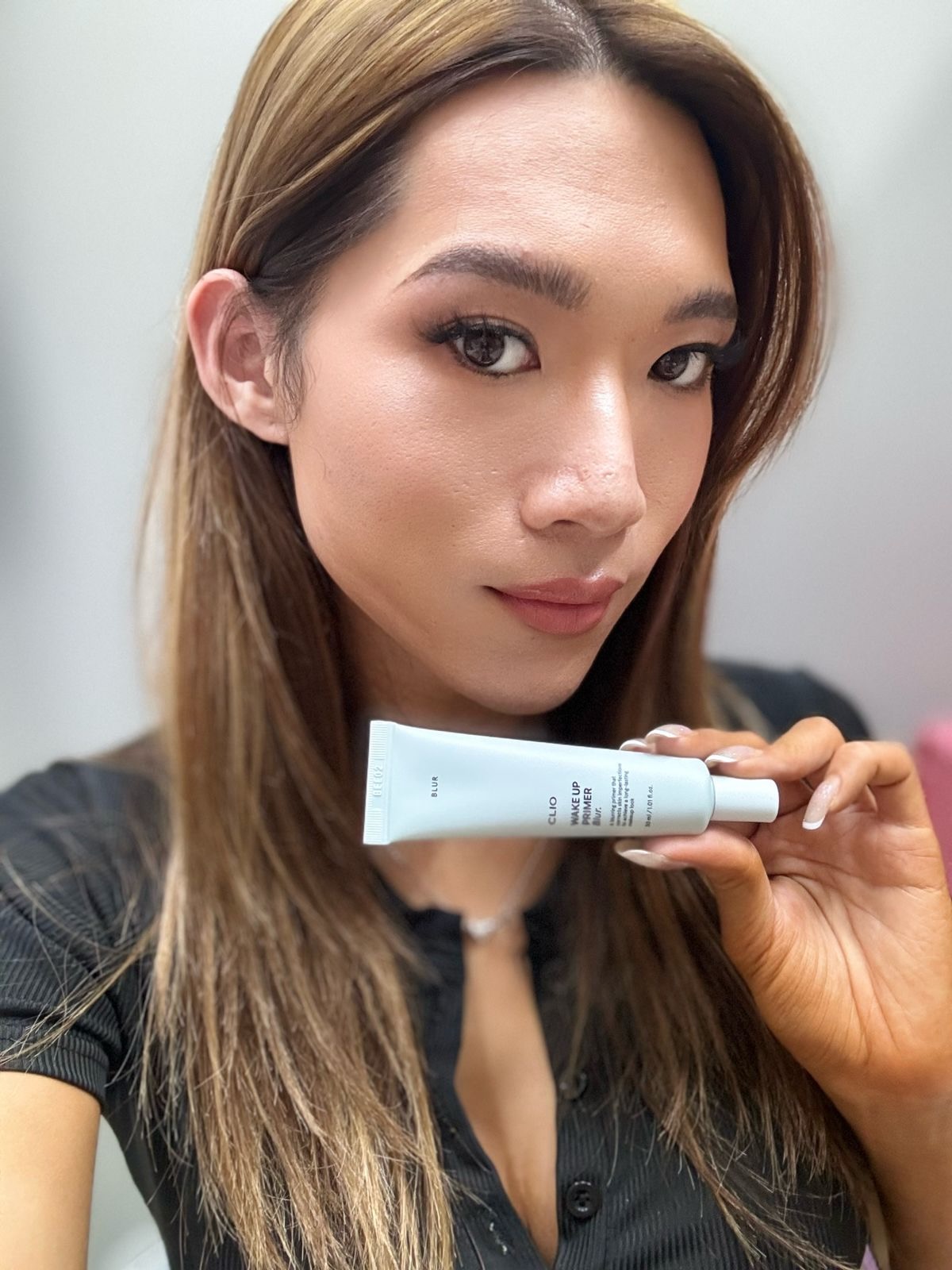 Maddie holding CLIO Wake Up Primer Blur