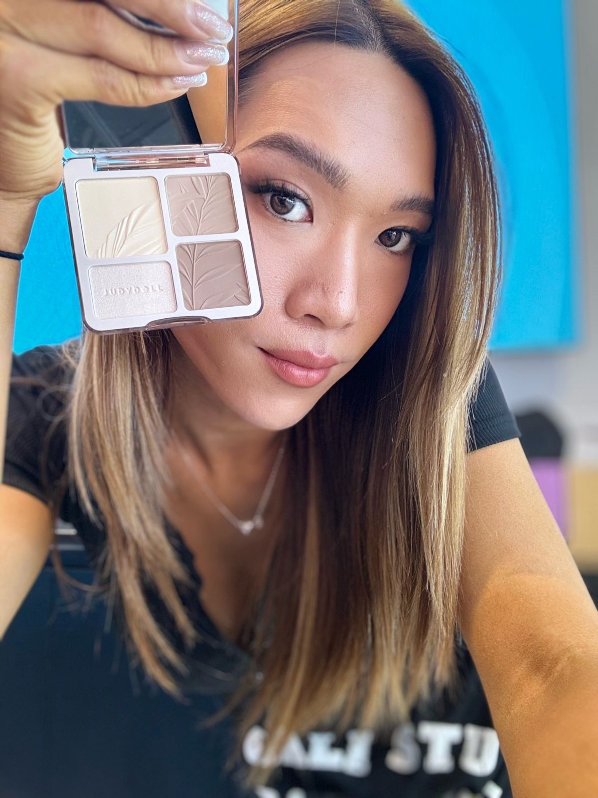 Maddie holding the Judydoll 2 in 1 Highlighter Contour Palette open
