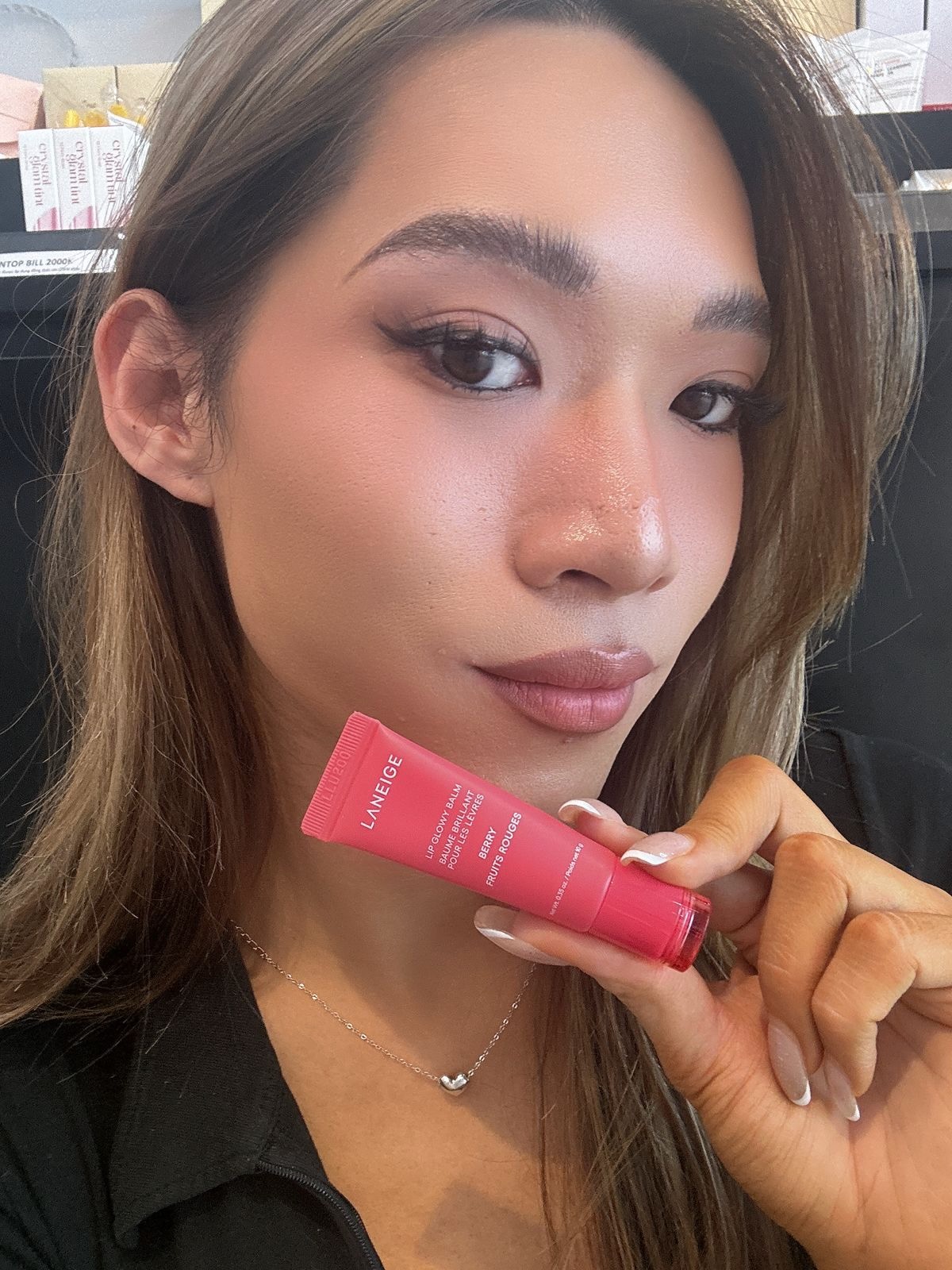 Maddie holding LANEIGE Lip Glowy Balm
